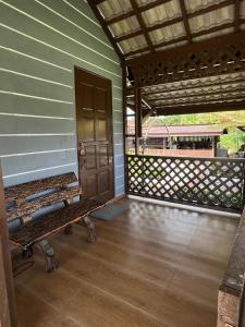 a porch of a house with a bench and a door at Wadi Al Hasyer Homestay Daisy in Juasseh