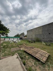 a group of tables and benches in a yard at Palm resort in Greater Noida