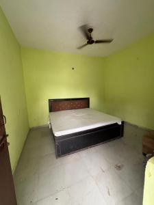 a bedroom with a bed with a ceiling fan at Palm resort in Greater Noida