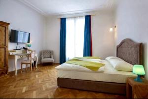 a bedroom with a bed and a desk with a computer at Hotel Pension Museum in Vienna +2 photos