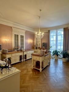 a large kitchen with wooden floors and a chandelier at Hotel Pension Museum in Vienna