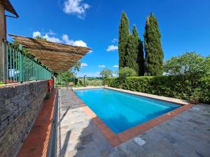 a swimming pool in front of a house with trees at Azalea Guest House in Siena