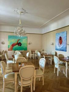 a dining room with tables and chairs and a chandelier at Hotel Pension Museum in Vienna