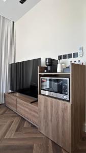 a microwave on a wooden stand in a kitchen at M Residence in Dhahran +33 photos