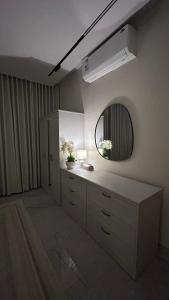 a bathroom with a sink and a mirror at M Residence in Dhahran