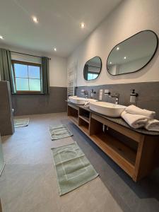a bathroom with two sinks and a large mirror at Ferienwohnungen Holzferienhäuser Leithenwald in Zwiesel +85 photos