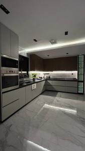 a large kitchen with stainless steel appliances in a room at M Residence in Dhahran