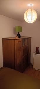 a room with a bed and a lamp on a cabinet at Chez Elsa et Agou - chambre confortable chez l'habitant in Courtepin +3 photos