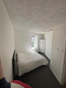 a bedroom with a bed in a white room at Kinsale central 5 in Kinsale