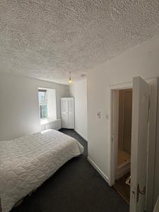 a white bedroom with a bed and a closet at Kinsale central 5 in Kinsale