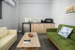 a living room with a green couch and a coffee table at Sea Breeze Stay 2 in Salamina