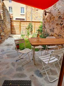 a wooden table and two chairs and a wooden table and chairs at Maison 2 chambres, pleine de Charme in Vic-le-Comte