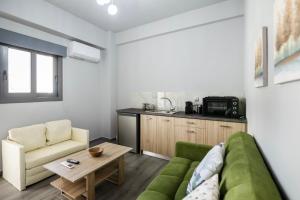 a living room with a green couch and a table at Sea Breeze Stay 2 in Salamina