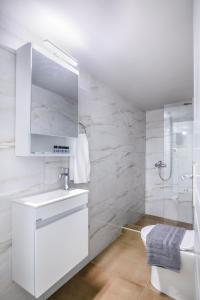 a white bathroom with a sink and a shower at Sea Breeze Stay 2 in Salamina +24 photos