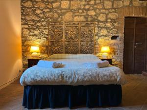a bedroom with a large bed with two lamps at Fiorire Casale Olistico in Attigliano