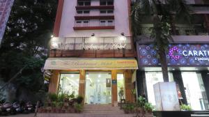 a store front of a pink building with a sign on it at The Boulevard Hotel in Jamshedpur