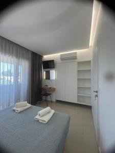 a bedroom with two white towels on a bed at Aestas Apartments in Agia Marina Nea Kydonias +83 photos