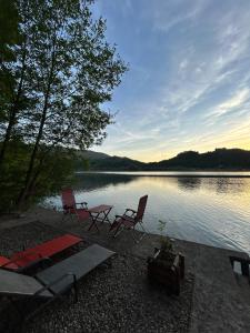 a group of chairs sitting next to a lake at Zmajeva Kuca in Mali Zvornik