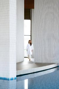 a woman in a white dress standing in a room at Mandala Hotel & Suites Hải Dương in Bảo Thap