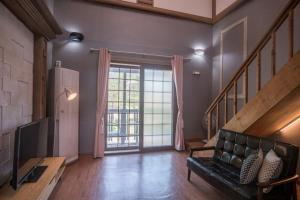 a living room with a couch and a television at Milyang Sweety Pension in Miryang +5 photos