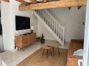 a living room with a tv and a couch at LAVAUR Location de meublé saissonier in Labastide-Saint-Georges