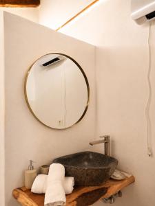 a bathroom with a stone sink and a mirror at La Paredita Casa Guimar in Tanque +47 photos