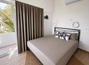 a bedroom with a bed with two pillows and a window at Spitaki Almyrida in Almyrida