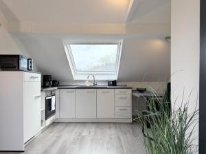 a kitchen with white cabinets and a window at Fewo Diemelsee 5 in Heringhausen