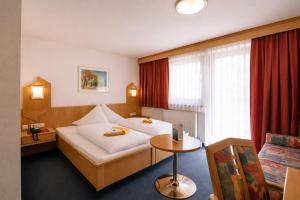 a hotel room with a bed and a table at Hotel Wiese in Sankt Leonhard im Pitztal +63 photos
