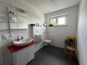 a white bathroom with a sink and a toilet at Businessapart Stuttgart in Gäufelden +58 photos