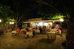 a group of people sitting at a restaurant at night at The Love Nest in Pissouri