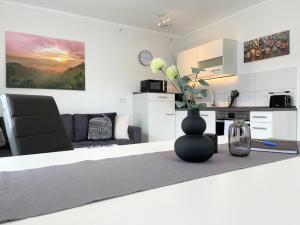 a white living room with a vase on a table at Fewo Diemelsee 2 in Heringhausen