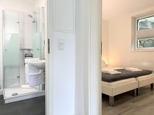 a bedroom with a bed and a bathroom with a shower at Fewo Diemelsee 2 in Heringhausen +11 photos
