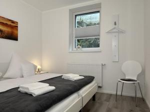 a bedroom with a bed with a chair and a window at Fewo Diemelsee 2 in Heringhausen