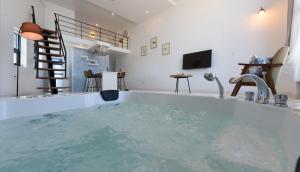 eine große Badewanne mit Wasser in einem Raum in der Unterkunft Cocomo Spa in Sokcho