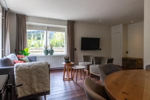 a living room with a table and chairs at De Bosberg Villa in Appelscha