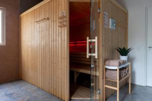 a room with a wooden partition with a glass door at De Bosberg Villa in Appelscha