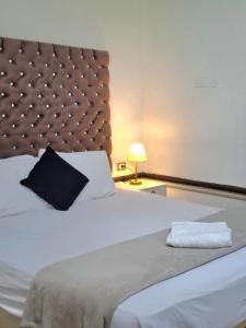 a bedroom with a large white bed with a black pillow at pal ace talaat harb in Cairo