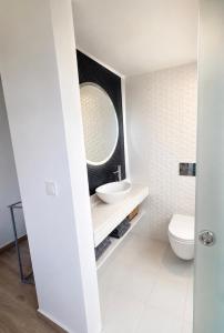 a white bathroom with a sink and a mirror at Spitaki Almyrida in Almyrida +5 photos