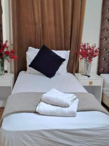 a bed with three towels sitting on top of it at pal ace talaat harb in Cairo