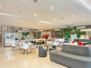 a restaurant with tables and chairs in a lobby at Front One Hotel Gresik in Panggang