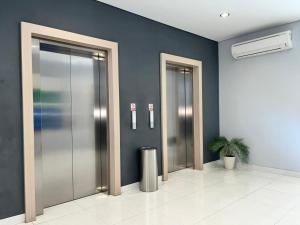 a row of elevators in a lobby with a plant at Front One Hotel Gresik in Panggang