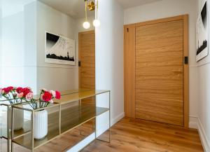 a hallway with a wooden door and a glass table with flowers at Gościniec in Sopot