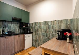 a kitchen with green cabinets and a table with flowers at Gościniec in Sopot +18 photos