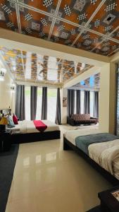 two beds in a large room with a ceiling with at Northview Hotel Hunza in Hunza Valley