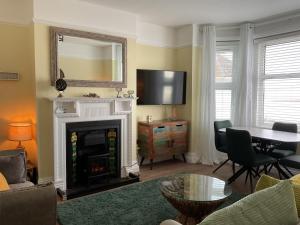 a living room with a fireplace and a table at Exmouth Devon Luxurious Flat OverlookingThe Sea in Exmouth