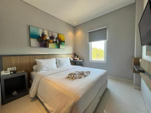 a bedroom with a large bed with a towel on it at Front One Hotel Gresik in Panggang