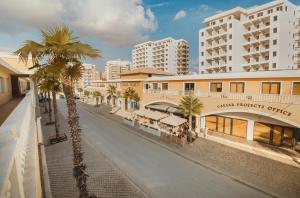 an empty city street with palm trees and buildings at Luxury 2 Bedroom Apartment in Caesar Resort in Iskele