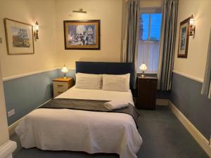 a bedroom with a bed and a window and two lamps at Yesterday's Guest House in Newtown