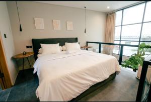 a bedroom with a large bed with white sheets at Wolu Designer Loft - Private Pool & Tropical Garden, Canggu in Tumbak Bayuh +17 photos